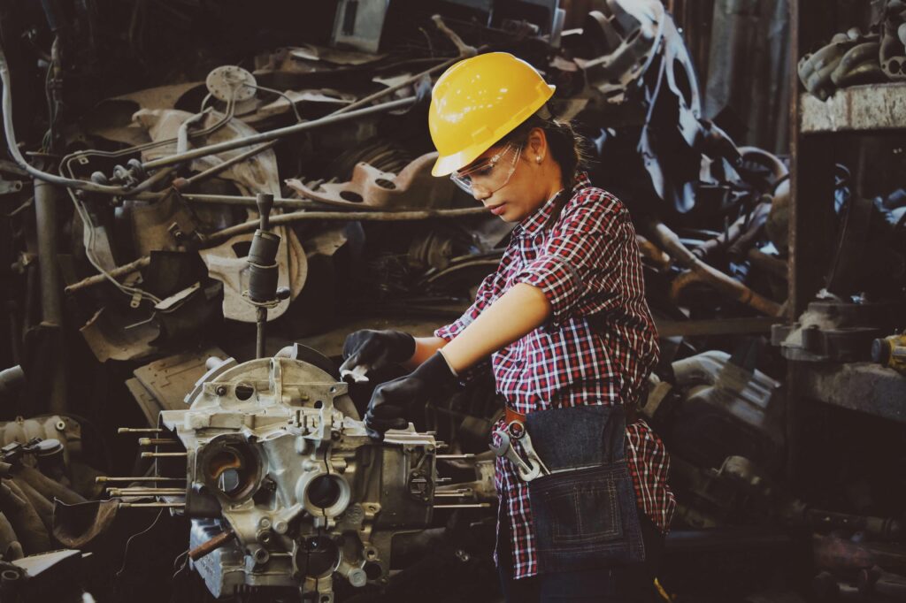 pexels photo 1108101 1108101 Woman engineer wearing safety gear, working on machine repair in an industrial setting.